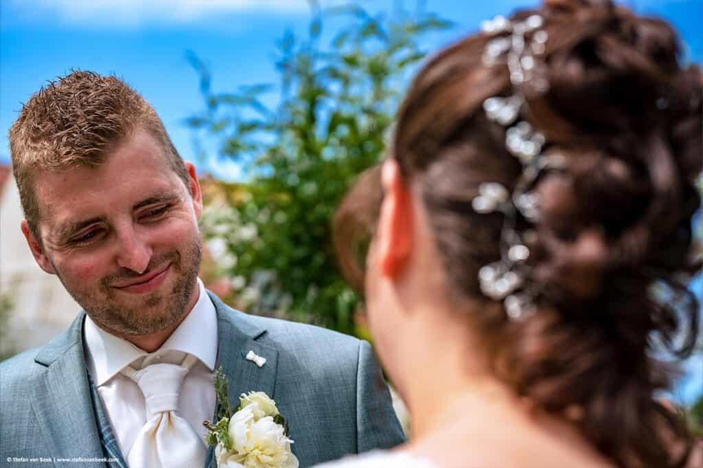 Bruidegom kijkt verliefd naar zijn bruid net voor het ja-woord tijdens ceremonie bij De Meerhoeve in Oud Ade © Stefan van Beek Fotografie