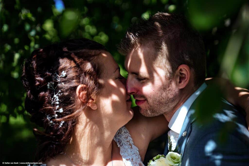 Close-up van intiem moment bruidspaar dat tegenover elkaar staat elkaar aankijkt net voor een zoen tijdens bruiloft fotoshoot de Burcht in Leiden © Stefan van Beek Fotografie