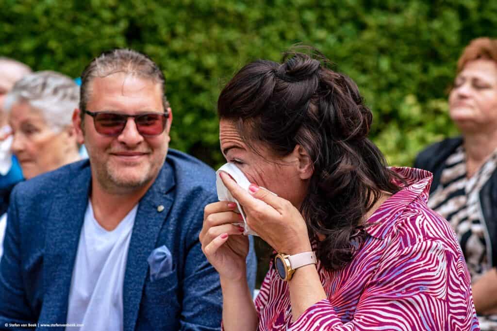 Sister of the bride wipes a tear away with a tissue during ceremony of the wedding at De Meerhoeve in Oud Ade the © Stefan van Beek Photography