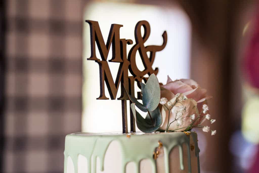Bordje Mr & Mrs boven op bruidstaart met groene kleur en pastel tint roos © Stefan van Beek Fotografie