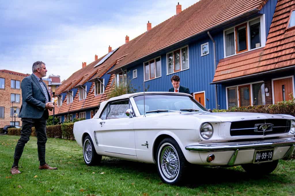 Bruidegom parkeert trouwauto Ford Mustang onder toeziend oog van zijn vader voor woning bruid in Zoetermeer © Stefan van Beek