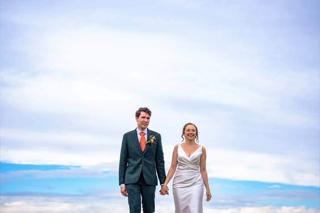 Wedding couple walking hand in hand in the clouds © by wedding photographer Stefan van Beek