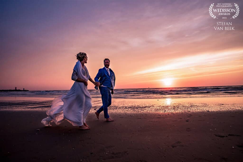 Wedisson Award Stefan van Beek wedding walking on the beach during sunset with purple orange sky